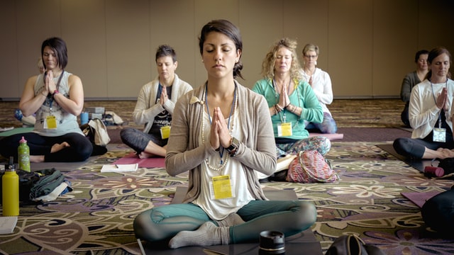 Women in a conference room meditating